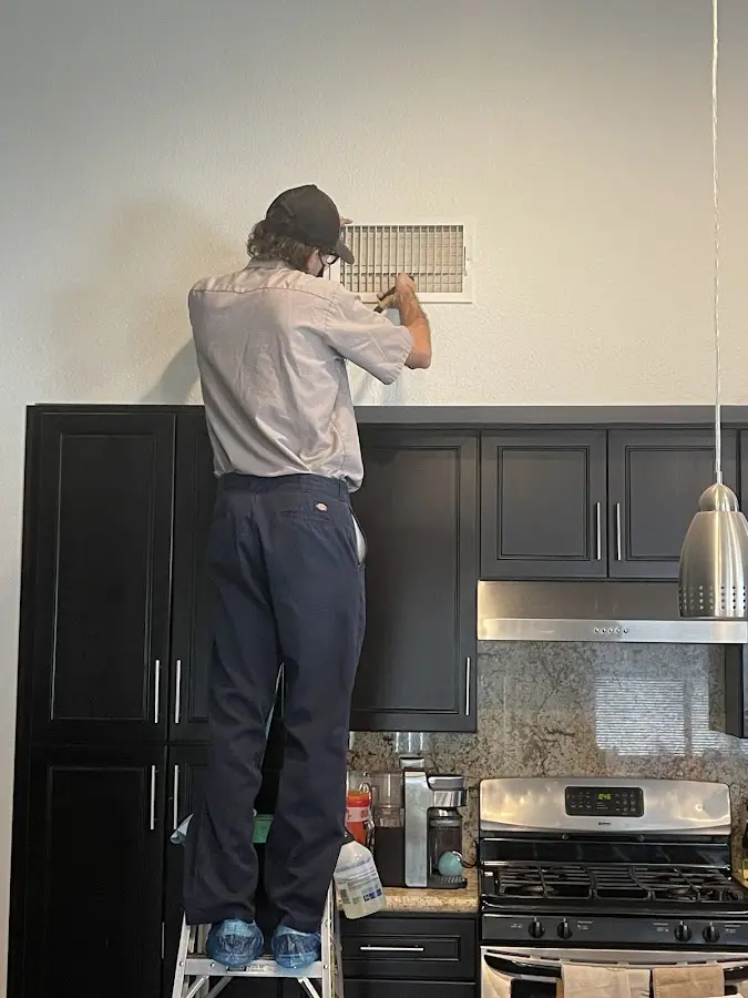 Technician inspecting an air vent during HVAC service in Haddonfield